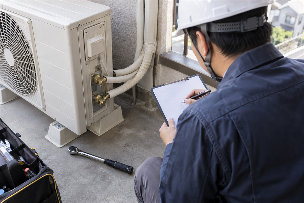 締付け後に工具と接続箇所を確認しながら施工票へ記入する作業員