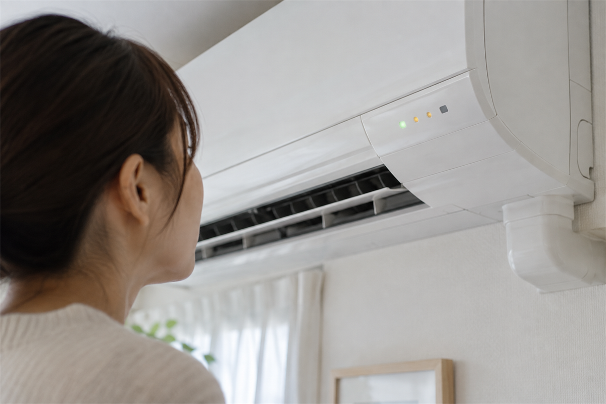 壁掛けエアコンの表示ランプを近くから確認する様子