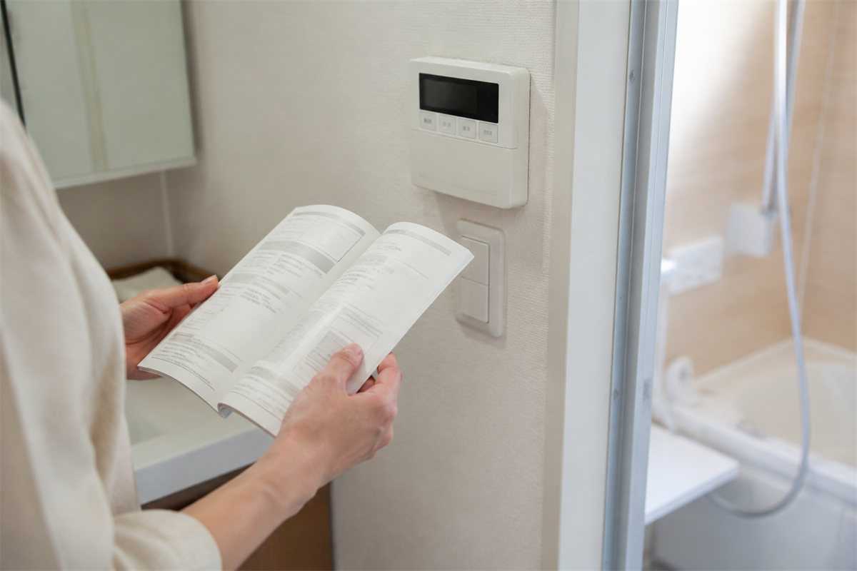 電源操作をせず給湯器の取扱説明書を確認する手元