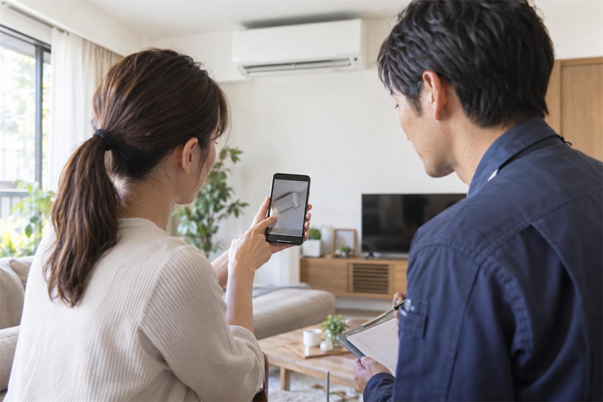 エアコンの状態を担当者へ説明する住人